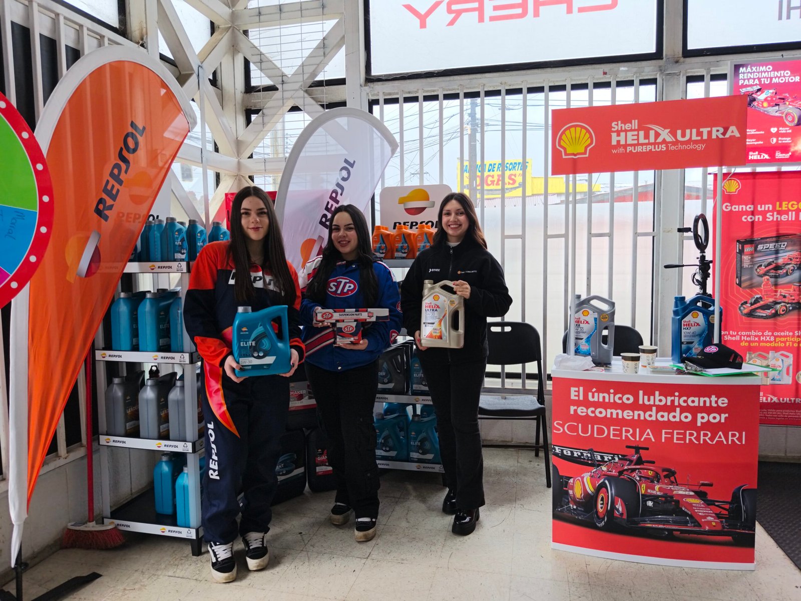 epresentantes de Repsol, STP y Shell exhibiendo lubricantes y productos automotrices durante el aniversario de Repuestos Fariña en Valdivia, con stands de capacitación y sorteos para clientes.